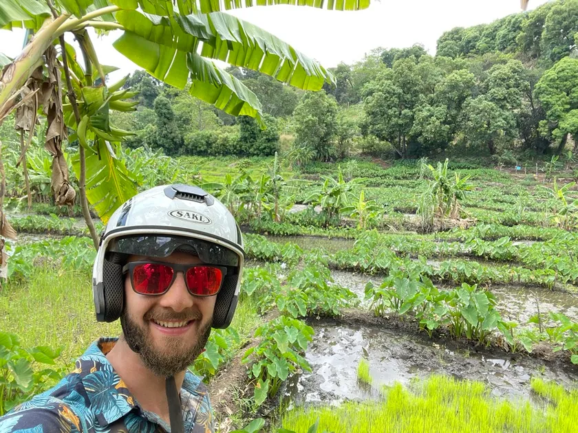 Filip Szarek wearing a motorbike helmet in front of farm fields